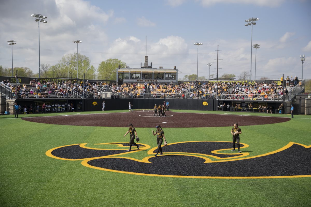 Iowa outfielders Tatianna Roman, Grace Banes, and  Bryce Klosterman break their huddle between innings during the first of a three-game softball series between Iowa and Minnesota at Bob Pearl Field on Saturday, April 27, 2024. The Gophers defeated the Hawkeyes 7-5.